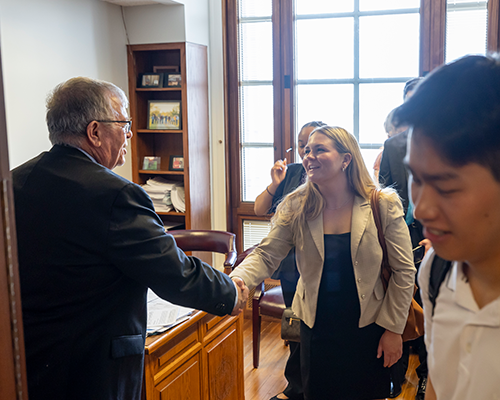 Student shaking hand of politician.