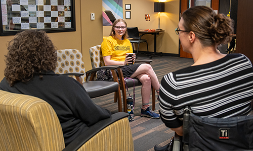 Students and staff talking in Disability Center lobby.