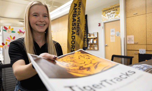 Involvement Ambassador handing packet to student.