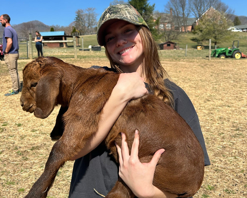 Student holding goat.