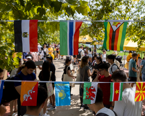 Students at event surrounded by flags.