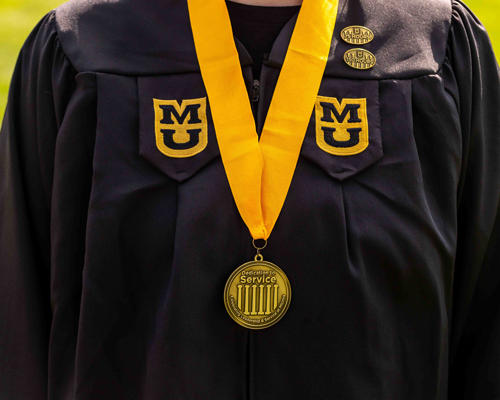 Student wearing pins and medal.