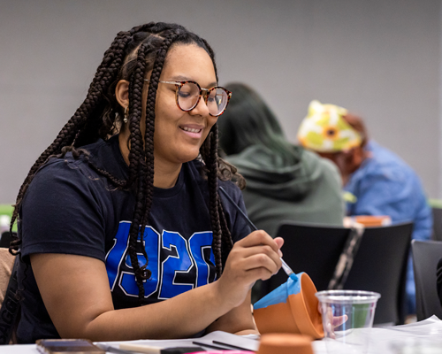 Student painting plant pot