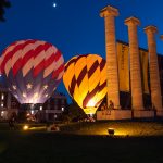 A Mizzou and American flag hot air balloon sit between the columns and Jesse Hall all lit up during Welcome Week 2018.