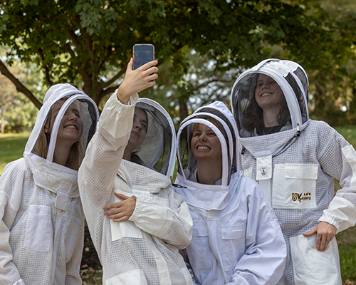 Students taking a picture at beekeeping event.